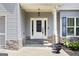 Close-up of a charming front porch with stone accents, a white door with glass panels, and stylish planters at 1016 Buckeye Ln, Villa Rica, GA 30180