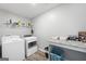 Bright laundry room features white washer and dryer, granite counter, and shelving at 1016 Buckeye Ln, Villa Rica, GA 30180