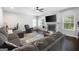 Cozy living room featuring a stone fireplace, a large gray sectional sofa, and a ceiling fan at 1016 Buckeye Ln, Villa Rica, GA 30180