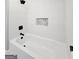 Sleek bathroom showcasing a modern soaking tub, textured tile walls, and contemporary fixtures at 1939 Sandringham Sw Dr, Atlanta, GA 30311