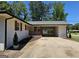 Side view of charming brick home featuring a covered carport, landscaped yard, and well-maintained curb appeal at 1939 Sandringham Sw Dr, Atlanta, GA 30311