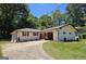 Charming brick home with a circular driveway, manicured lawn, and lush greenery, offering a welcoming curb appeal at 1939 Sandringham Sw Dr, Atlanta, GA 30311
