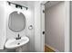 Modern bathroom with a pedestal sink, updated fixtures, and a framed round mirror at 89 Prospect Path, Hiram, GA 30141