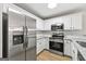 Modern kitchen featuring stainless steel appliances, white cabinets, and granite countertops at 89 Prospect Path, Hiram, GA 30141