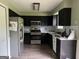 Modern kitchen with stainless steel appliances, dark cabinets, and tile backsplash at 150 Doe Run Ct, Sharpsburg, GA 30277