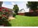 Backyard showing flowering rose bushes, mature landscaping, and views of the screened porch at 613 Blackburn Ln, Peachtree City, GA 30269
