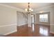 Open-concept living area with hardwood floors, neutral paint, and elegant chandelier above dining table at 613 Blackburn Ln, Peachtree City, GA 30269