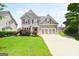 Two-story home with manicured lawn, brick accents, a two-car garage, and attractive landscaping at 613 Blackburn Ln, Peachtree City, GA 30269