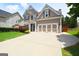 Two-story home with a large driveway and a two-car garage, surrounded by well-maintained landscaping at 613 Blackburn Ln, Peachtree City, GA 30269