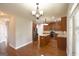 Open-concept kitchen with dark wooden cabinets, stainless steel appliances, and pendant lighting at 613 Blackburn Ln, Peachtree City, GA 30269