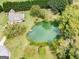 Beautiful aerial view showcases the home, lush landscaping, and a picturesque pond at 557 Arrowhead Cir, Rutledge, GA 30663