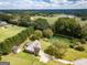 Aerial view of a home with a large yard, pond, and surrounding trees at 557 Arrowhead Cir, Rutledge, GA 30663