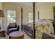This bedroom features a four-poster bed, carpet, and an ottoman at 557 Arrowhead Cir, Rutledge, GA 30663