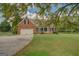 Charming front exterior featuring a brick facade, a wide driveway, and beautiful landscaping at 557 Arrowhead Cir, Rutledge, GA 30663