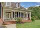 Inviting front porch with brick steps, white columns, and a charming rose bush at 557 Arrowhead Cir, Rutledge, GA 30663