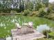 Dock on a large pond with table and chairs for relaxing by the water at 557 Arrowhead Cir, Rutledge, GA 30663