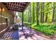 Relaxing back porch with wood flooring and railing overlooking a green wooded area at 65 Cobblestone Crk, Peachtree City, GA 30269