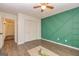 Bright bedroom with stylish green accent wall, closet, wood floors, and ceiling fan at 65 Cobblestone Crk, Peachtree City, GA 30269