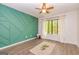 Modern bedroom featuring a decorative green wall, hardwood flooring and a plush area rug at 65 Cobblestone Crk, Peachtree City, GA 30269