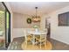 Cozy dining area with modern chandelier, seating for four, and sliding glass doors to the outside at 65 Cobblestone Crk, Peachtree City, GA 30269