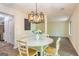 Inviting dining room showcasing a modern chandelier, a round table with seating for four, and wood-look flooring at 65 Cobblestone Crk, Peachtree City, GA 30269