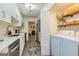 Bright kitchen with white cabinets, stainless appliances, and a convenient laundry area at 65 Cobblestone Crk, Peachtree City, GA 30269