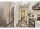Galley kitchen featuring stainless steel appliances, white cabinetry, and a decorative accent rug at 65 Cobblestone Crk, Peachtree City, GA 30269