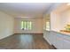 Open living room with wood-look floors, window view, and pass-through to kitchen counter at 65 Cobblestone Crk, Peachtree City, GA 30269