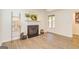 Bright living room with a decorative fireplace, wood-look floors, and a window allowing natural light at 65 Cobblestone Crk, Peachtree City, GA 30269