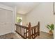 Bright staircase with hardwood railings leading to the next level, with a window offering natural light at 65 Cobblestone Crk, Peachtree City, GA 30269