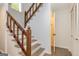 Modern staircase with wood railing and wood-look flooring, complemented by clean, white walls at 65 Cobblestone Crk, Peachtree City, GA 30269