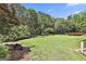 Spacious backyard with mature trees and a hammock in the distance at 106 Hidden Springs Ln, Peachtree City, GA 30269