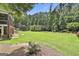Huge backyard featuring an expansive lawn, mature trees and landscaping, with brick accents at 106 Hidden Springs Ln, Peachtree City, GA 30269