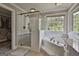 Bathroom showcasing a glass shower, soaking tub under a bright window, and vanity with granite countertop at 106 Hidden Springs Ln, Peachtree City, GA 30269