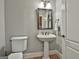 Cozy half bathroom with a pedestal sink, mirror and toilet at 106 Hidden Springs Ln, Peachtree City, GA 30269