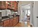 Butler's pantry with wood cabinets, granite countertop, a mirrored backsplash, and access to the dining room at 106 Hidden Springs Ln, Peachtree City, GA 30269