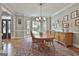 Open dining room with a large bay window, hardwood floors, traditional furnishing, and decorative light fixtures at 106 Hidden Springs Ln, Peachtree City, GA 30269