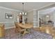 Elegant dining area featuring hardwood floors, neutral paint, trim detail, light fixture, and traditional-style table set at 106 Hidden Springs Ln, Peachtree City, GA 30269