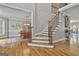 Bright foyer with hardwood floors and stairs with decorative iron and wood banister leads to dining room at 106 Hidden Springs Ln, Peachtree City, GA 30269