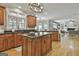 Open-concept kitchen with wood cabinets, granite countertops, a large island and hardwood flooring at 106 Hidden Springs Ln, Peachtree City, GA 30269
