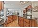 Open concept kitchen with granite countertops, wood cabinets and hardwood floors leading to the living room at 106 Hidden Springs Ln, Peachtree City, GA 30269