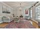 Bright living room featuring a light gray sofa, neutral walls, hardwood floors, and an attractive overhead light fixture at 106 Hidden Springs Ln, Peachtree City, GA 30269