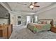 Bright main bedroom featuring a trey ceiling, ceiling fan, fireplace and adjoining bath at 106 Hidden Springs Ln, Peachtree City, GA 30269