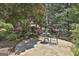 Cozy outdoor patio area surrounded by lush landscaping and trees at 106 Hidden Springs Ln, Peachtree City, GA 30269