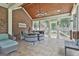Cozy screened-in patio with brick accent wall, wood ceiling, and comfortable seating area at 106 Hidden Springs Ln, Peachtree City, GA 30269