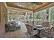 Inviting screened porch with wicker furniture, ceiling fans, tile floor and wooded backyard views at 106 Hidden Springs Ln, Peachtree City, GA 30269