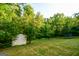 Wide backyard featuring a fire pit, lush landscaping and storage shed at 155 Cottage Cir, Fayetteville, GA 30215