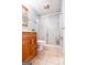 Compact bathroom with wooden vanity, tiled floor, and shower with sliding doors, maximizing space and functionality at 155 Cottage Cir, Fayetteville, GA 30215
