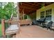 Covered deck features bench seating, fan, grill, and stairs leading to an outdoor trampoline and fire pit at 155 Cottage Cir, Fayetteville, GA 30215