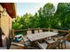 Spacious wooden deck features an outdoor dining table set in a lush, wooded backyard at 155 Cottage Cir, Fayetteville, GA 30215